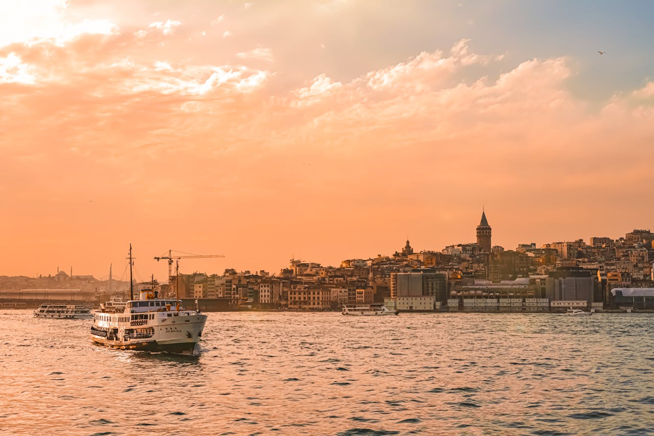 hero-img-02 Beautiful view of Istanbul's skyline and ferry during a vibrant sunset over the Bosphorus.